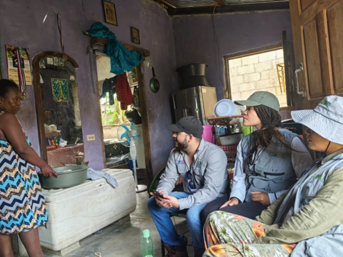 Speaking with a resident in a flood-vulnerable neighborhood about her experiences and recovery since Hurricanes Eta and Iota of 2020, San Pedro Sula, Honduras.
